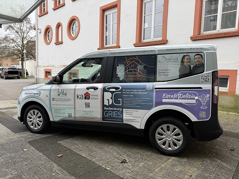 Werbefahrzeug mit Ka Immobilien Trier Anzeige, geparkt vor historischem Gebäude in Trier
